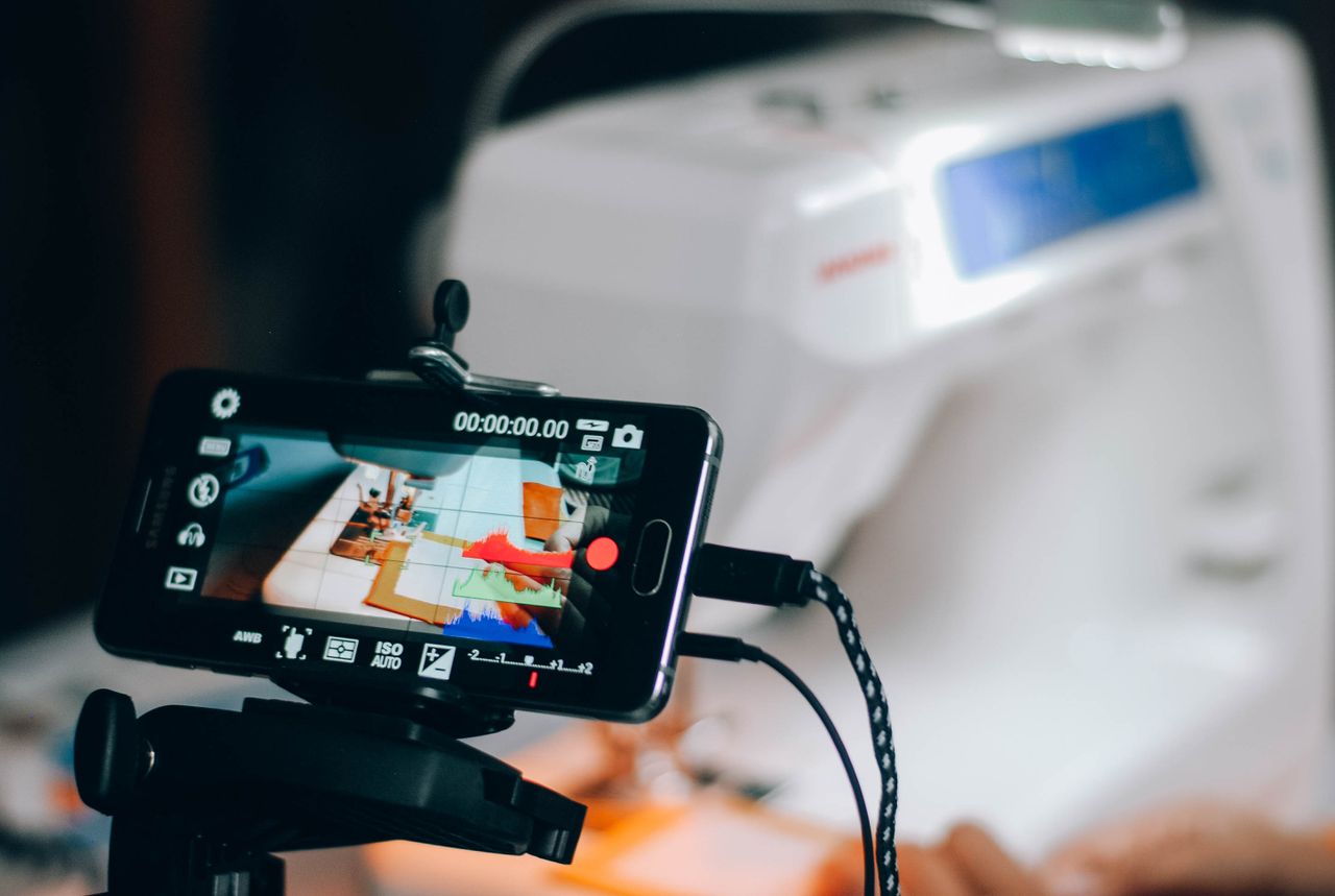 Smartphone capturing sewing machine process, perfect for DIY and crafting content.